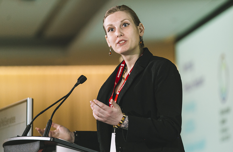 A woman named Jade speaking at a podium to an audience