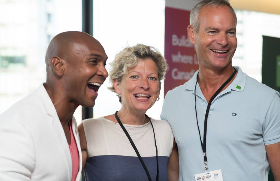 Three speakers taking a photo together at a conference